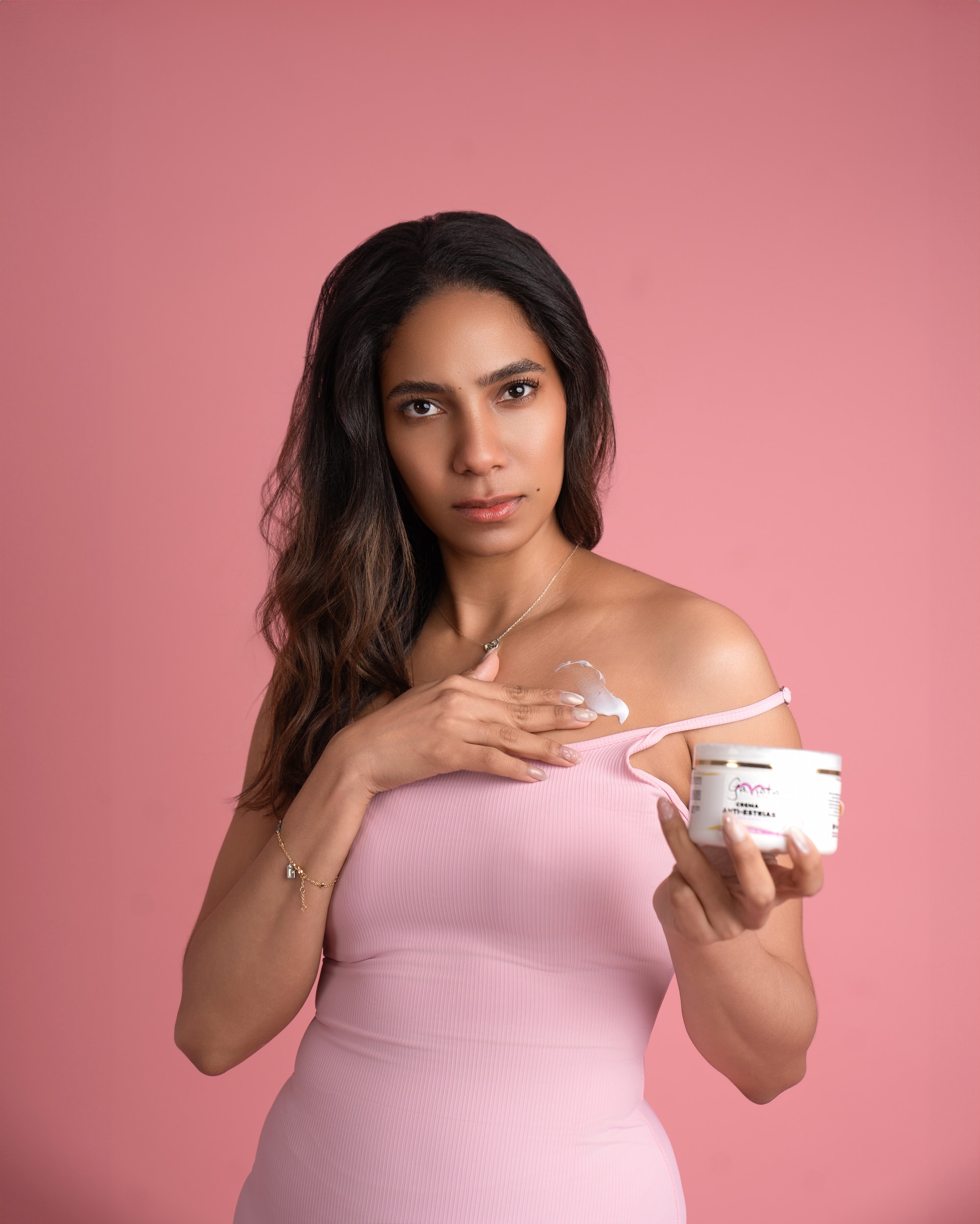 Woman applying a Gaviota by Lia cream to her shoulder