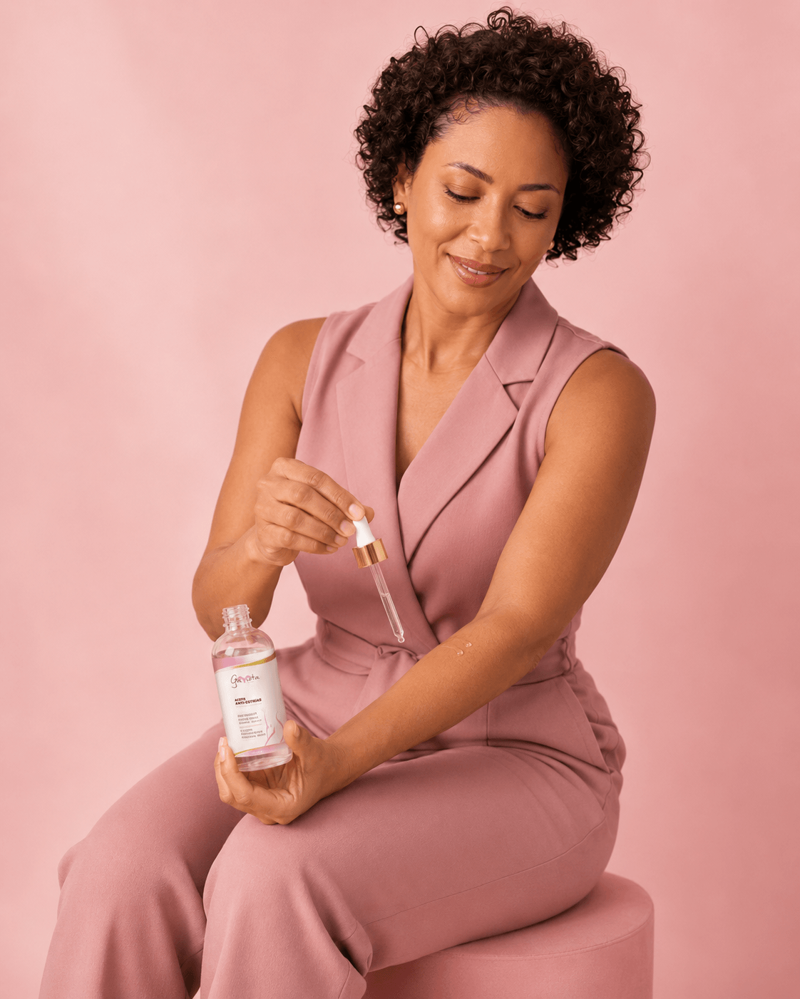 Woman applying Gaviota by Lia Stretch Mark Body Oil to her forearm with a dropper.